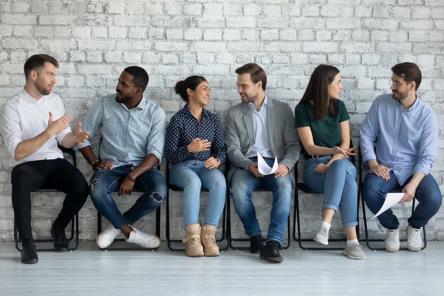 Colleagues talking in a row of chairs
