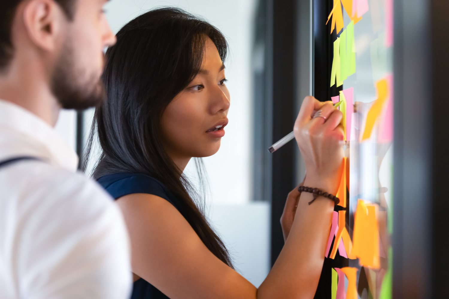 Professional writing on sticky notes on a Kanban board