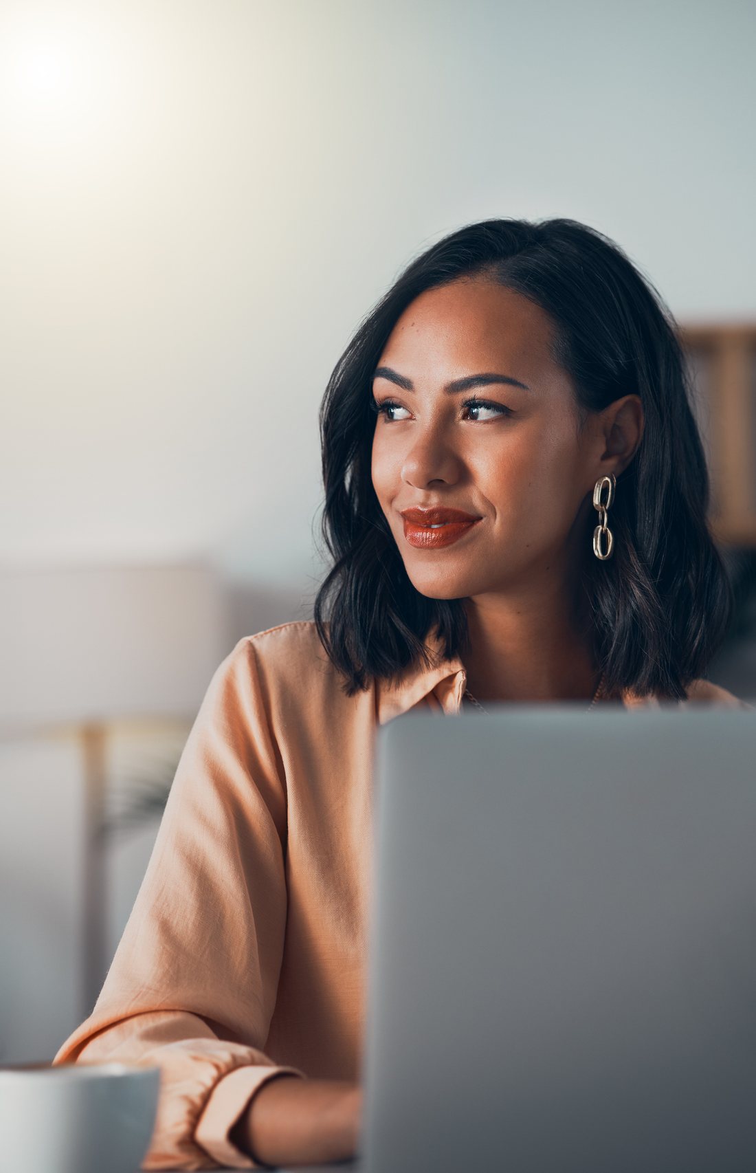 Professional at her laptop, looking ahead